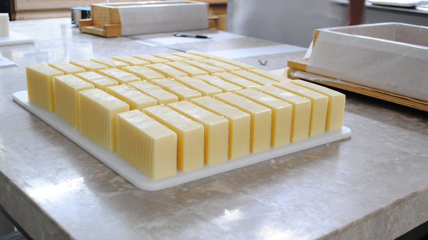 Bars of cut soap  and the soap molds on a table 